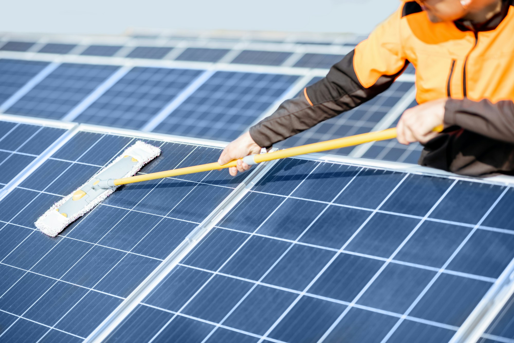 Workman cleaning solar panels